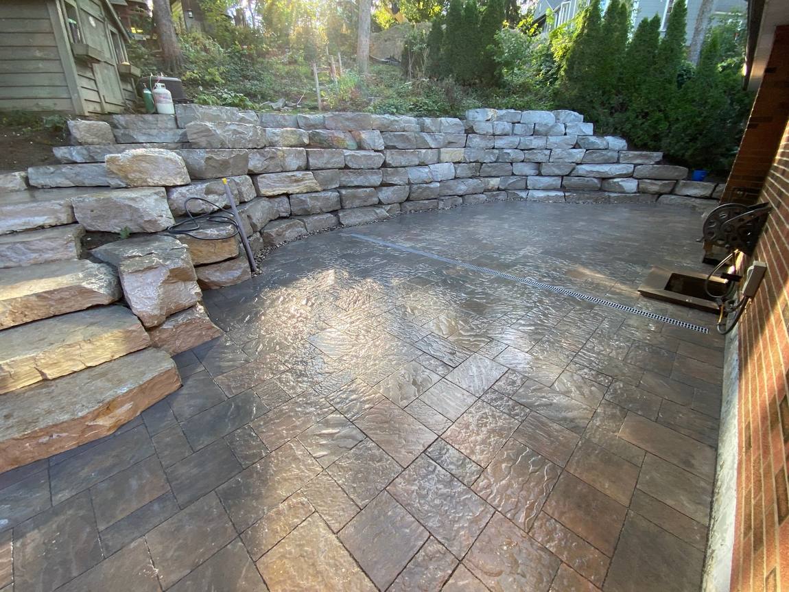 Stamped concrete patio and armour stone retaining wall