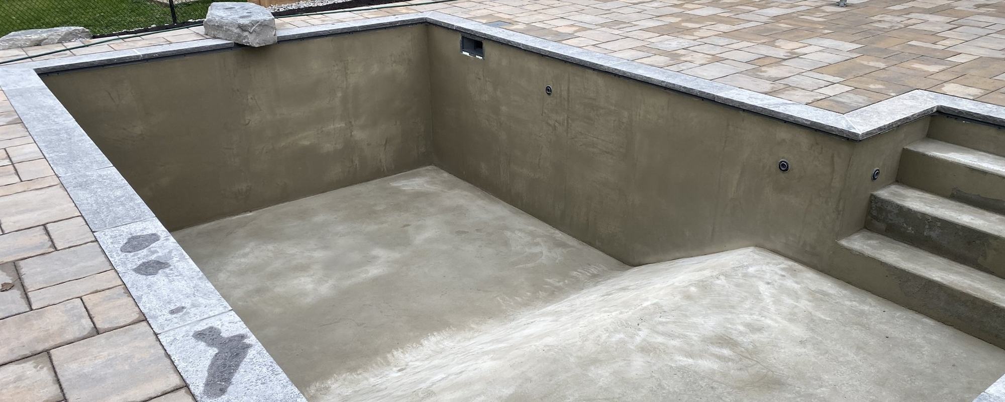 Concrete pool shell with natural stone coping